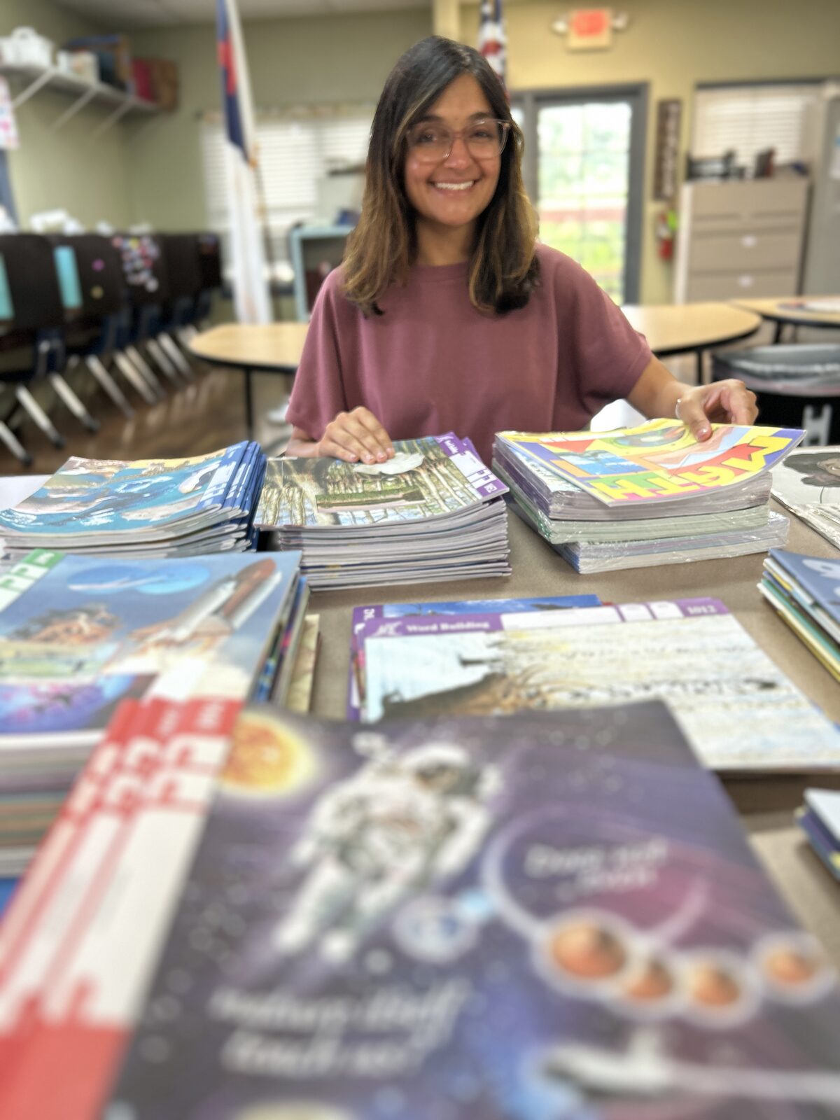 Staff member with A.C.E. School of Tomorrow PACE curriculum workbooks