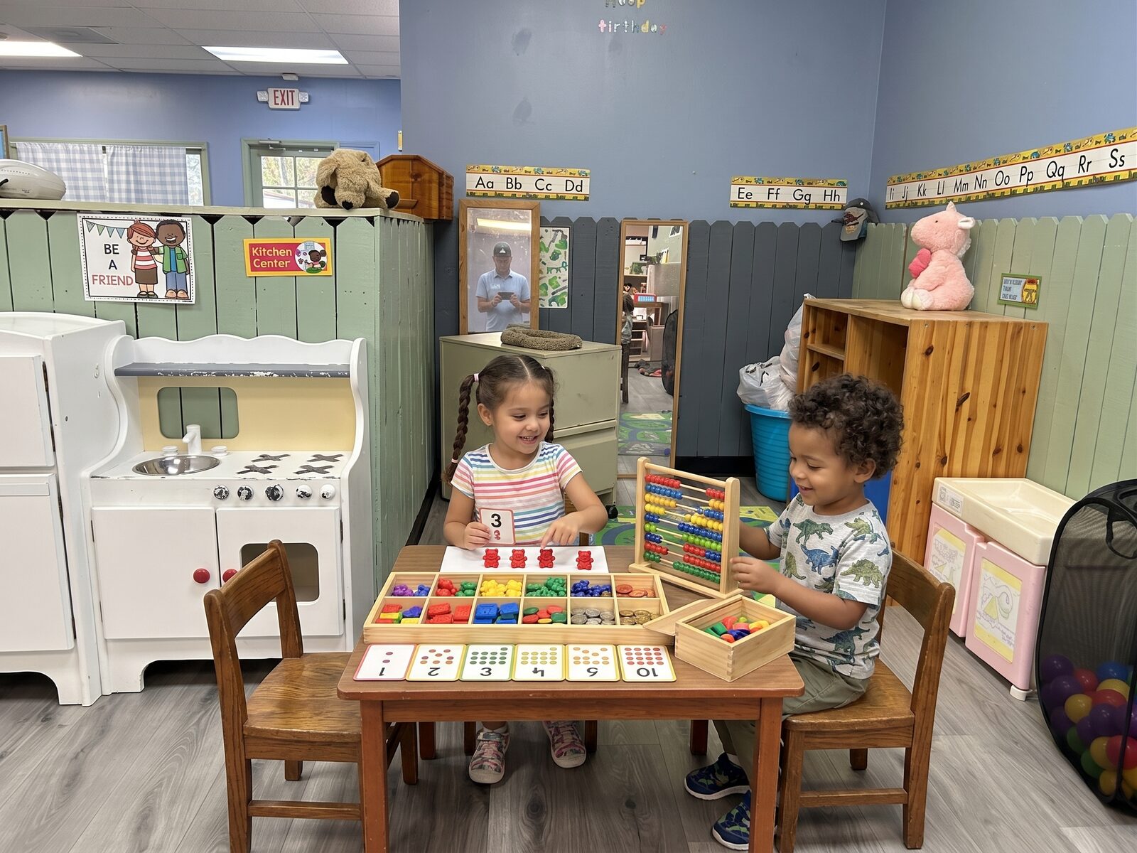 PreK students practicing counting with an abacus and manipulatives